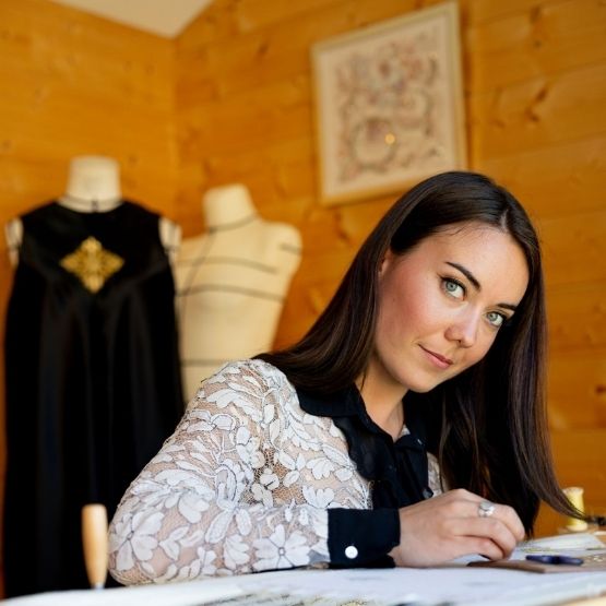 Femme travaillant sur des dessins de mode dans son atelier textile.