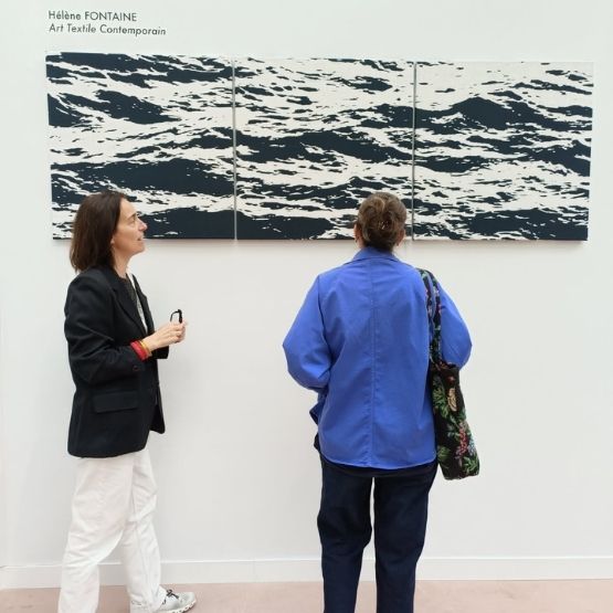 Femme observant des œuvres d'art textile dans une galerie.